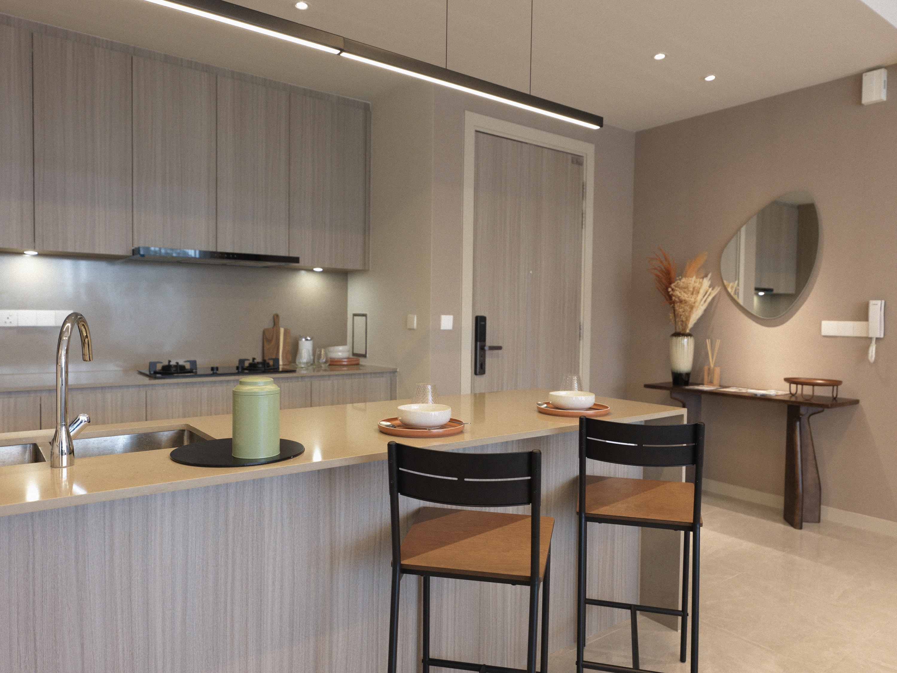 Contemporary kitchen and dining space with warm neutral tones and ambient architectural lighting