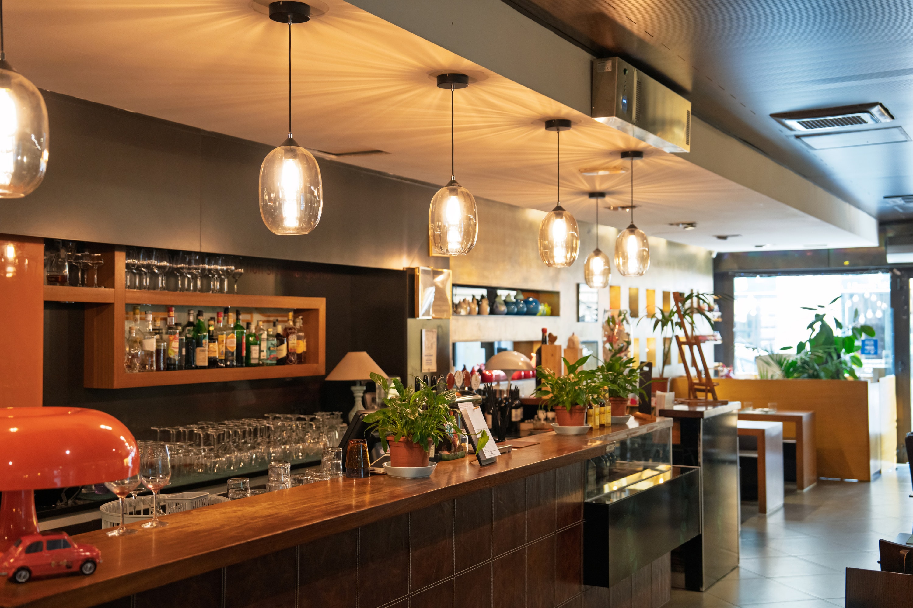 Restaurant bar with warm pendant lighting and polished timber surfaces